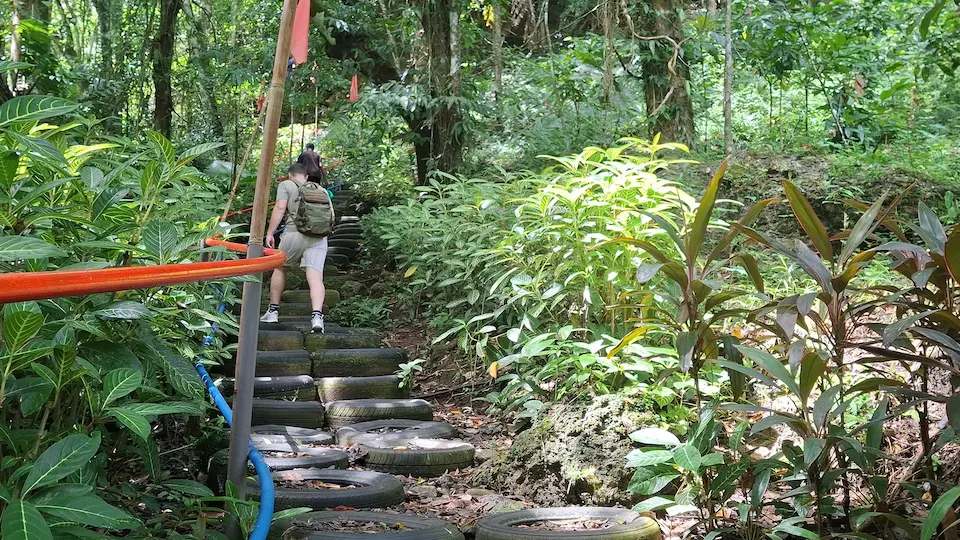 Hikers ascending Solong Hill using recycled car tire steps