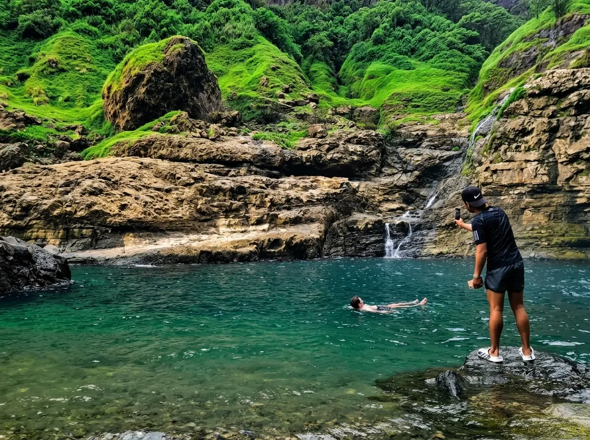 Tourists swimming and resting at the pristine catch basin of Aw-Asen Falls