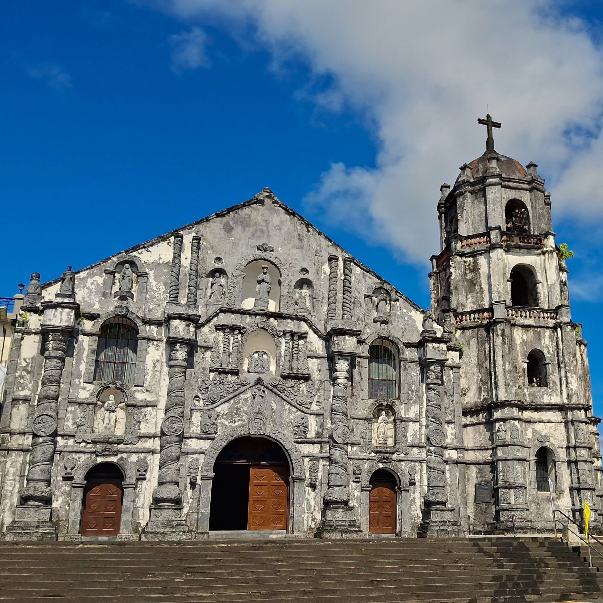 Travelers walking the courtyard of Daraga Church