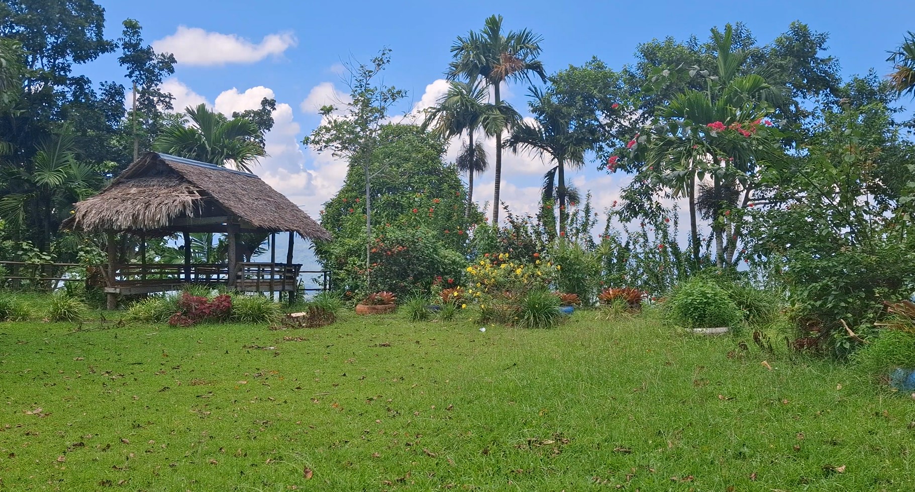 Native nipa hut resting area surrounded by lush tropical gardens at Kawa Kawa Hill
