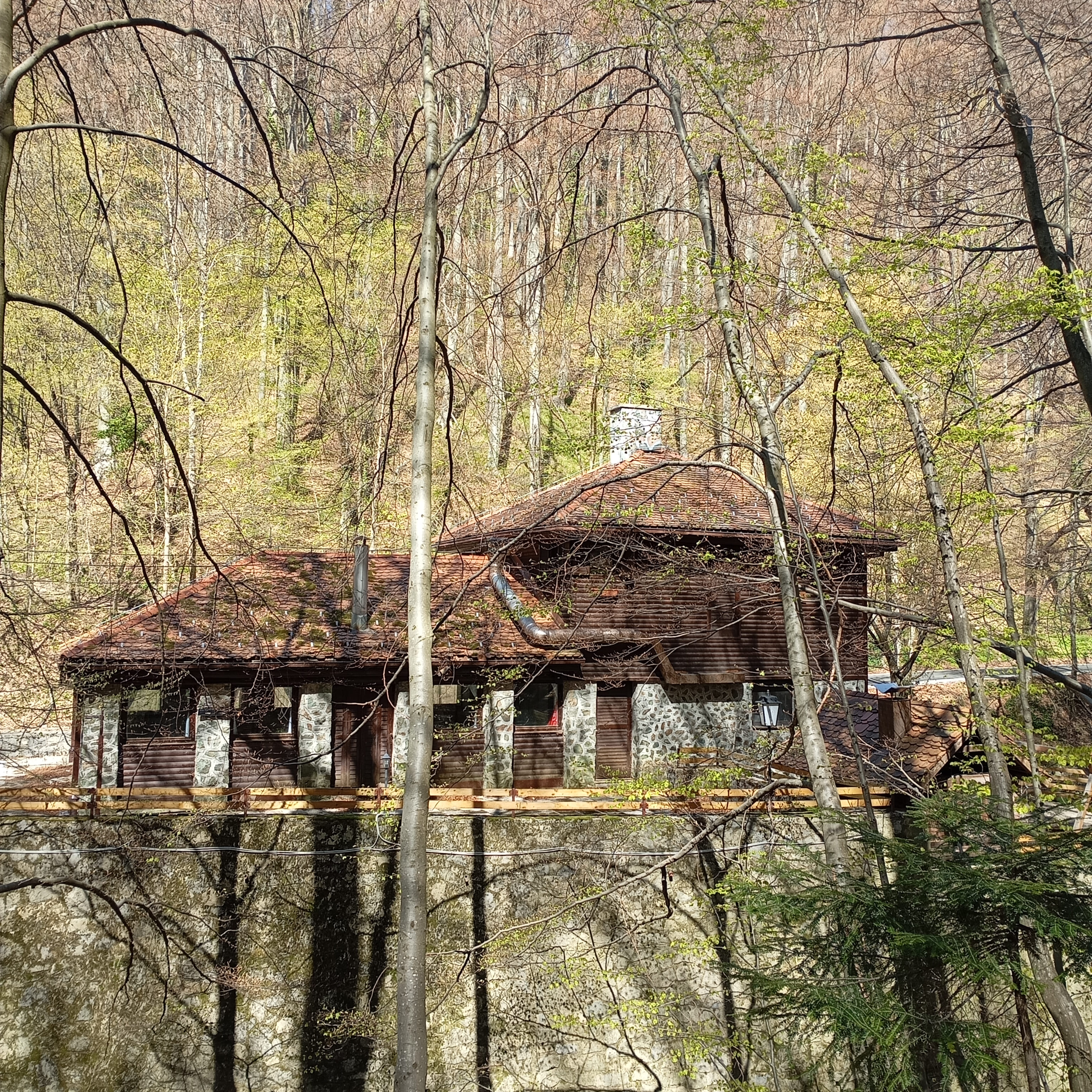 Rustic stone and wood lodge at Kraljičin Zdenac trail in Medvednica Nature Park, Zagreb, surrounded by trees
