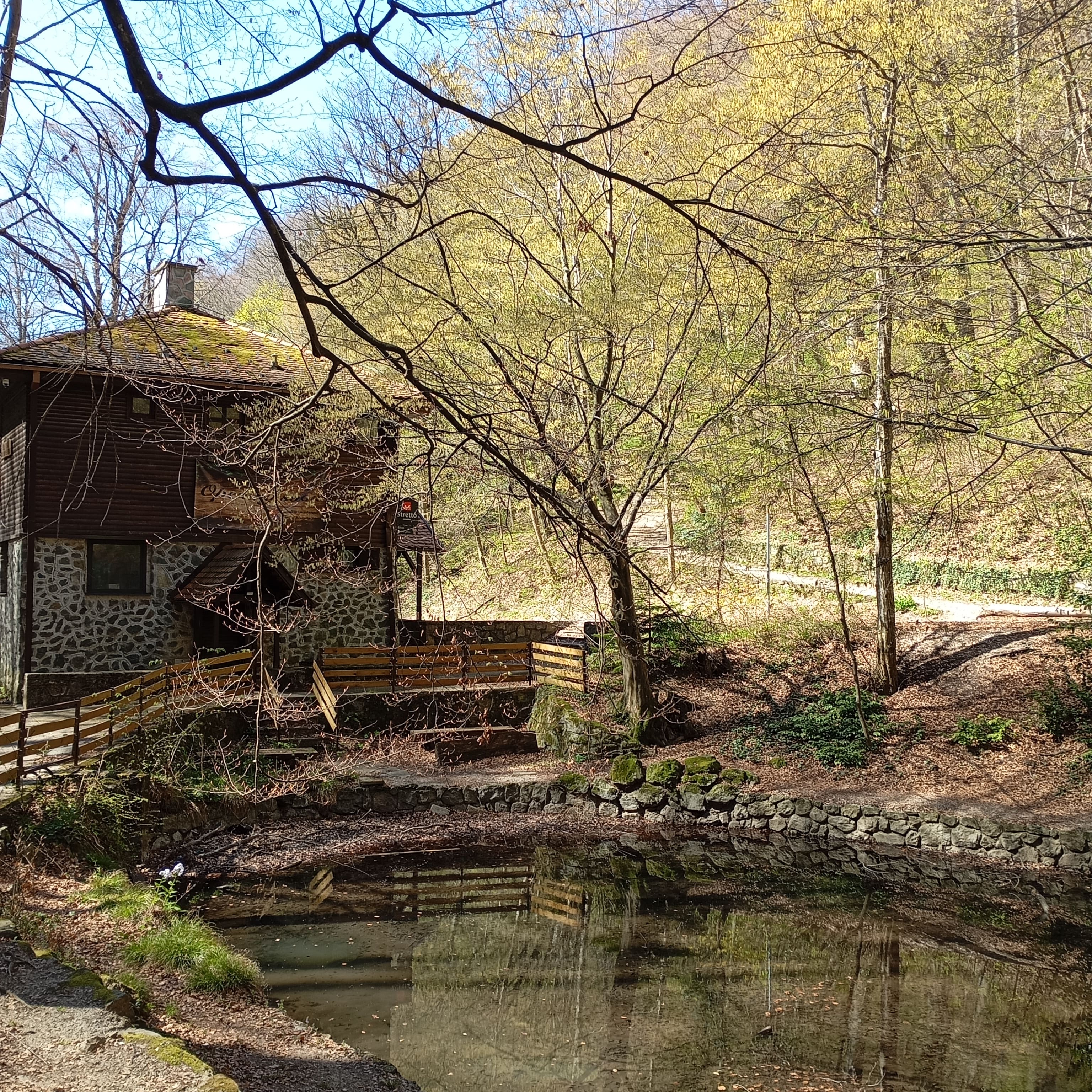Kraljičin Zdenac lodge with stone wall and pond in Medvednica Nature Park, Zagreb, surrounded by trees