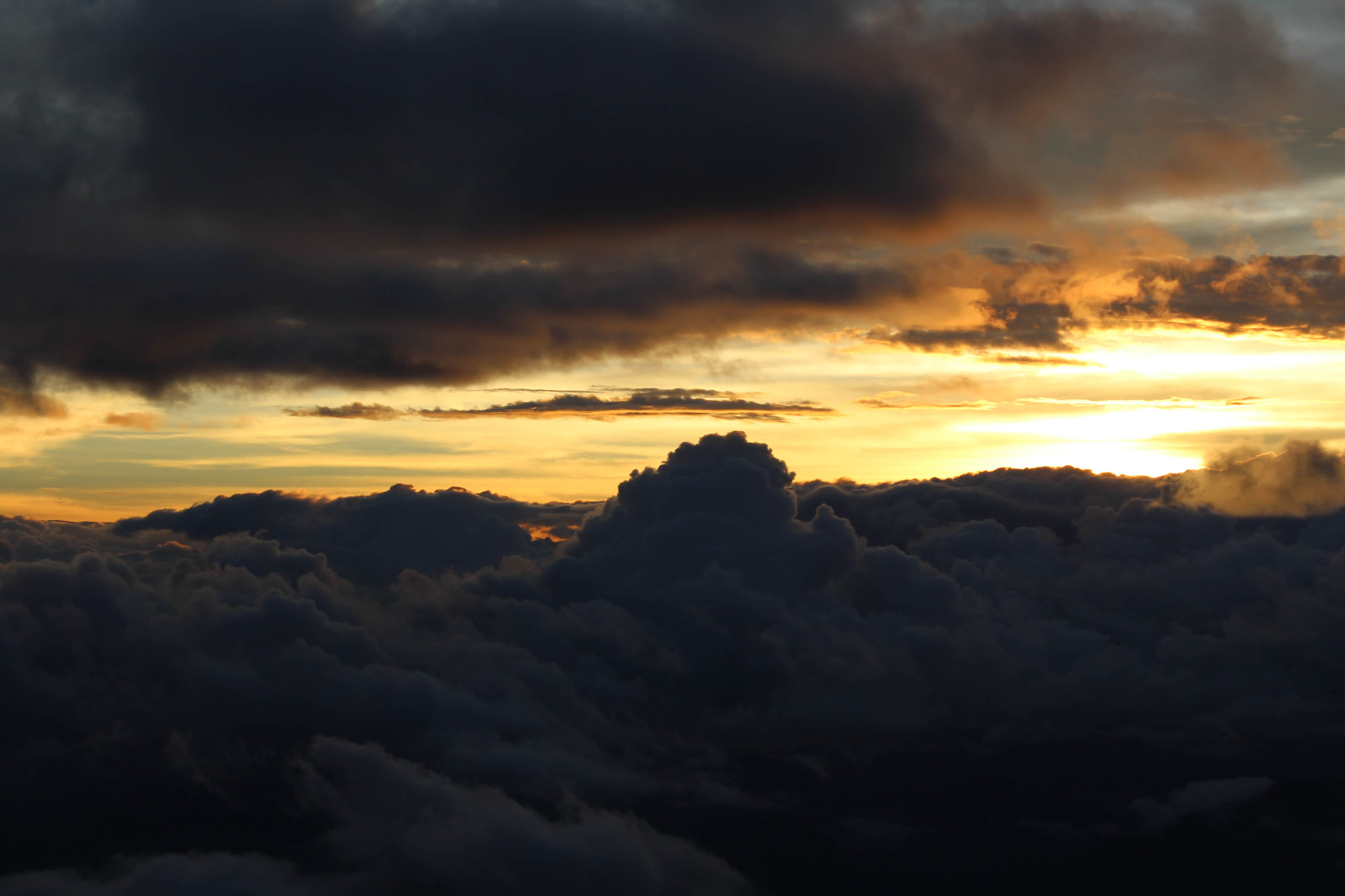 Mount Pulag sea of clouds at sunrise with golden light breaking through dark clouds