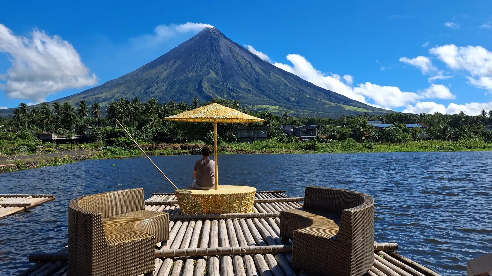 Tourists relaxing on a traditional bamboo raft with comfortable chairs gliding across Sumlang Lake